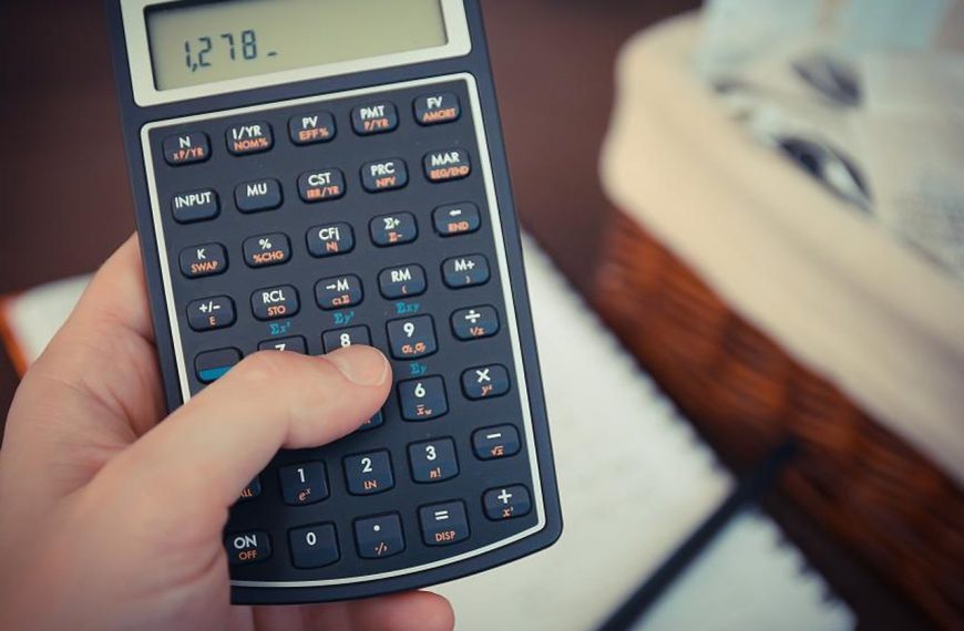 Hands using a calculator on a desk with papers