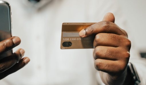Person using a smartphone and credit card for online shopping or payment.
