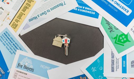 Overhead view of real estate brochures and house key, ideal for marketing.